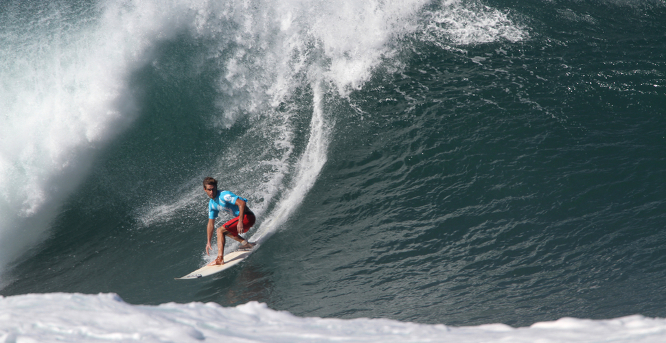 A surfer in a North Shore Hawaii competition catches a wave