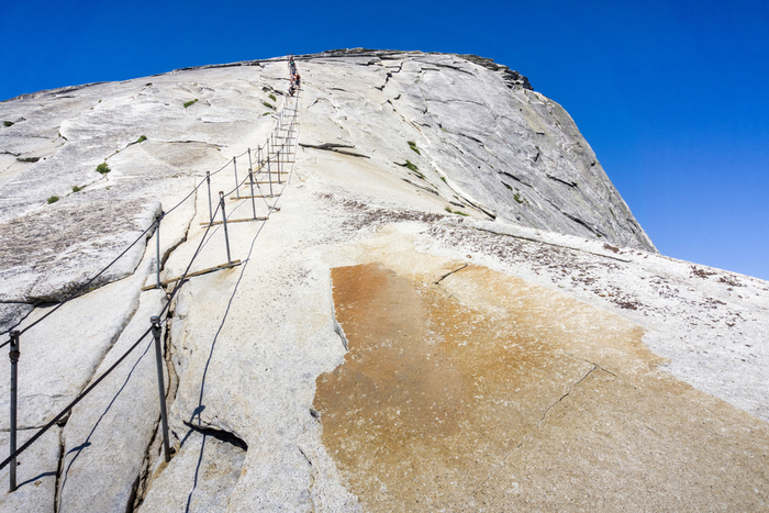 Hikers need the assistance of steel cables to get to the top of Half Dome