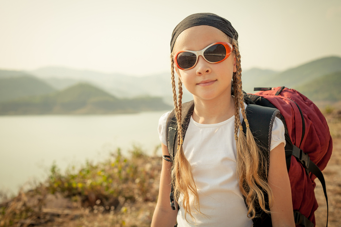 Hip little girl with backpack and sunglasses