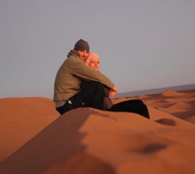 6 Destinations for Couples Who Travel OBP Travel Designer Julianne Mohr and her husband sit on the sand dunes of Morocco