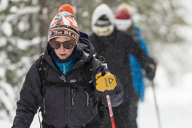 woman leading a group Cross-country skiing the trails around Old Faithful in Yellowstone National Park