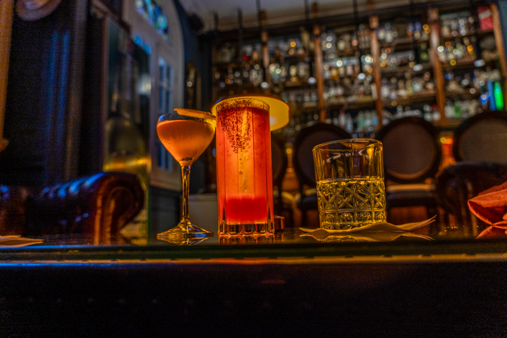 Cocktails on a bar, with dark background and moody lighting, in Palermo, Buenos Aires